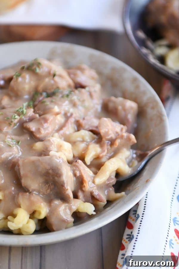 Forkful of slow cooker beef stroganoff over spaetzle.