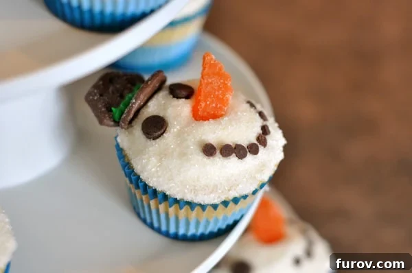 Charming snowman vanilla buttermilk cupcakes arranged on a tiered serving stand, ready for a festive gathering.