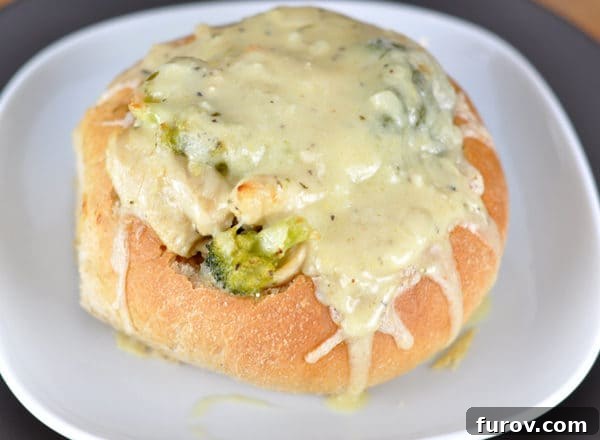 Golden Cordon Bleu Bread Bowls 3 An overhead shot of a Chicken Cordon Bleu Bread Bowl, showcasing the bubbly, melted cheese covering the chicken, ham, and broccoli filling within the crispy bread.
