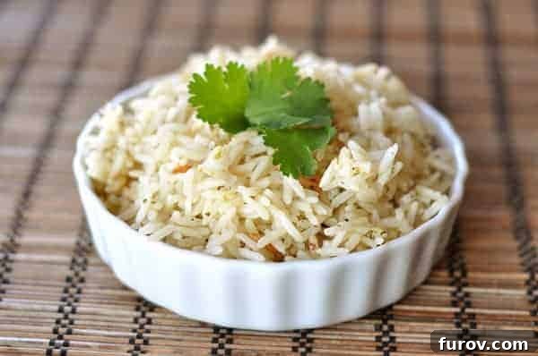 A white ramekin filled with cooked cilantro lime rice and topped with fresh cilantro sprigs.
