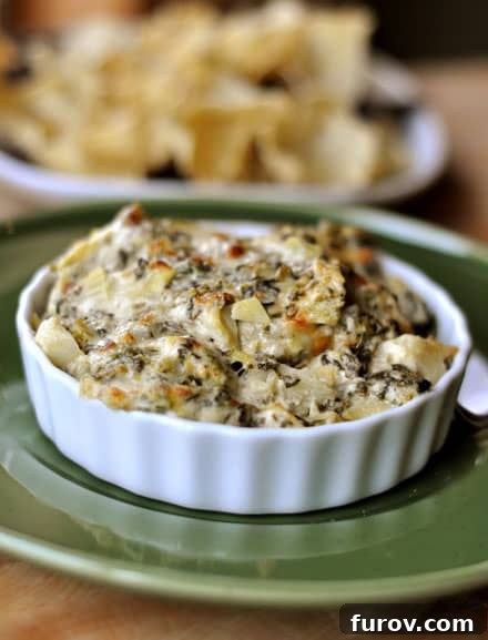 Ultimate Creamy Spinach Artichoke Dip 10 Spinach artichoke dip beautifully presented in a small white ramekin, ready for serving.
