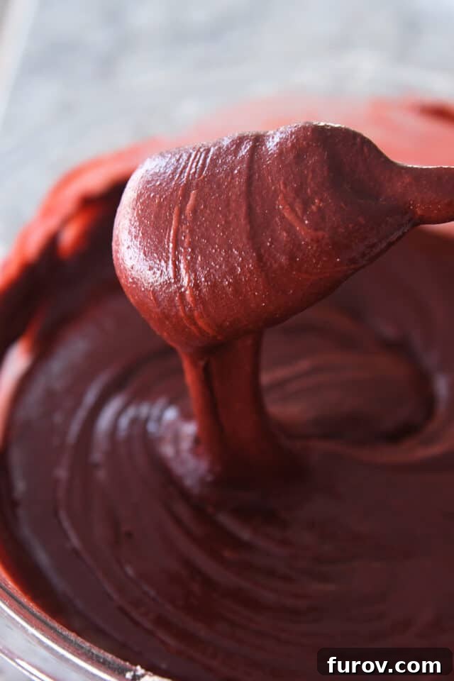 Spatula stirring red velvet brownie batter.
