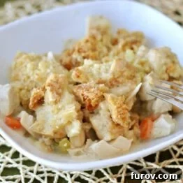 Close-up of a rustic Chicken Pot Pie Crumble with golden Parmesan topping, served in a white baking dish.