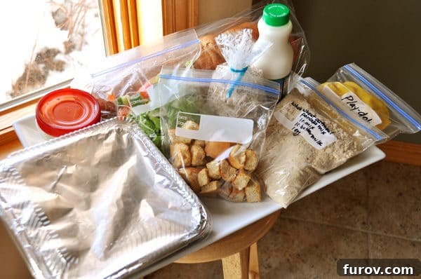 A large white tray overflowing with various individually bagged and containerized food items, showcasing a complete take-in meal for new parents.