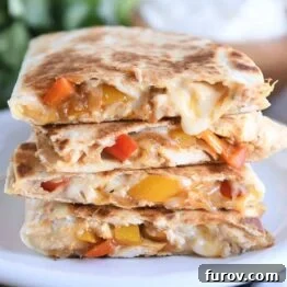four chicken quesadilla triangles stacked on white plate