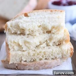 four half slices of baked sourdough peasant bread stacked on parchment paper