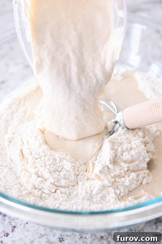 Pouring in sourdough discard to bowl with flour.
