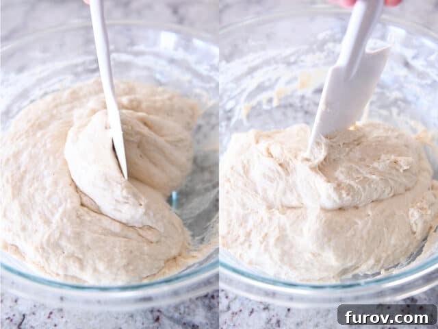 Scraping wet sourdough peasant bread dough from sides of glass bowl with rubber spatula.