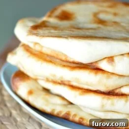 Stacked Naan bread on a blue plate.