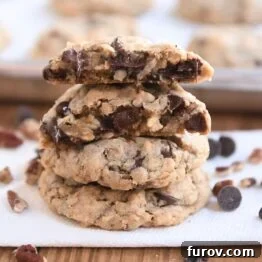 Two cowboy cookies stacked with one cookie broken in half on top, showcasing the perfect texture and delicious mix-ins.