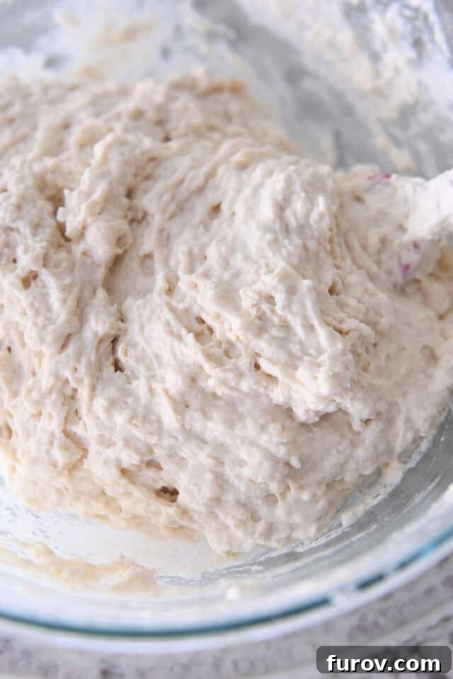 Smooth, thick biscuit dough resting in a clear glass mixing bowl, ready for the next step of preparation.