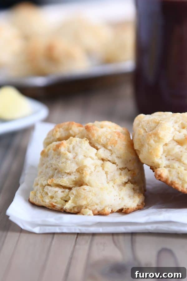 Easy flaky buttermilk drop biscuits on white napkin, showcasing their golden-brown tops and soft interior.