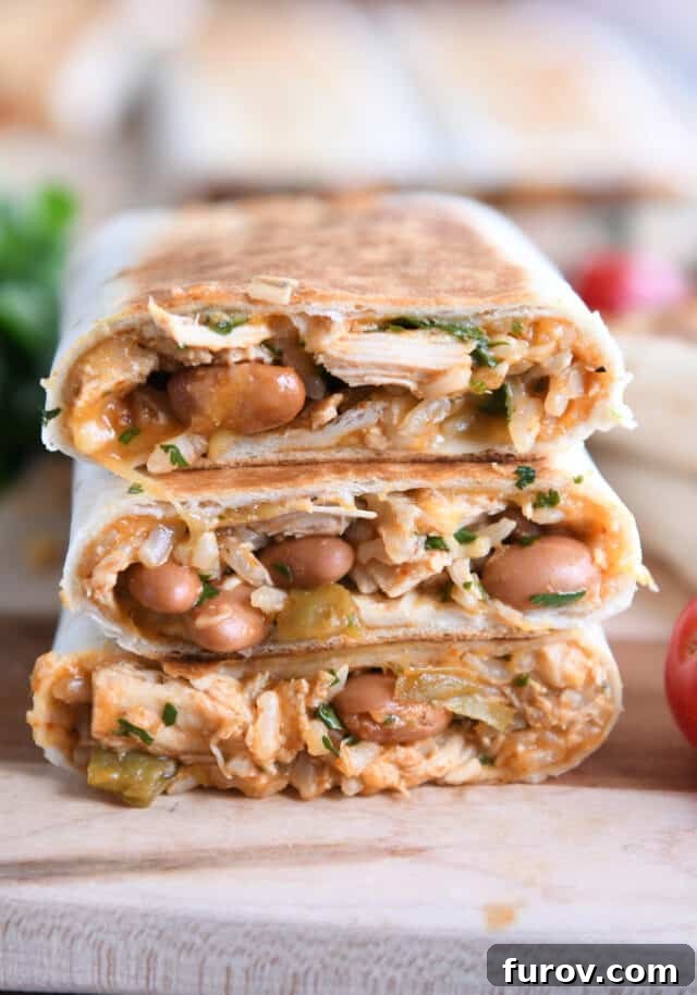 Cheesy Crispy Chicken Enchilada Wraps 2 Three golden-brown crispy chicken enchilada wraps stacked neatly on a wooden cutting board, ready to be sliced and served.