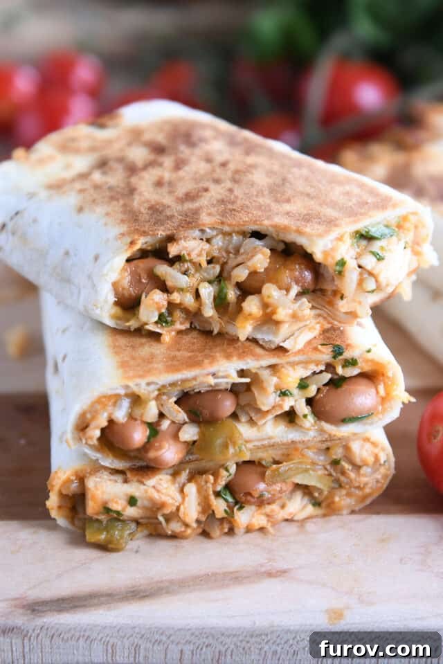 Cheesy Crispy Chicken Enchilada Wraps 7 Three perfectly crispy enchilada wraps artfully stacked on top of each other, with a satisfying bite taken out of the top wrap, revealing the savory, cheesy filling within.