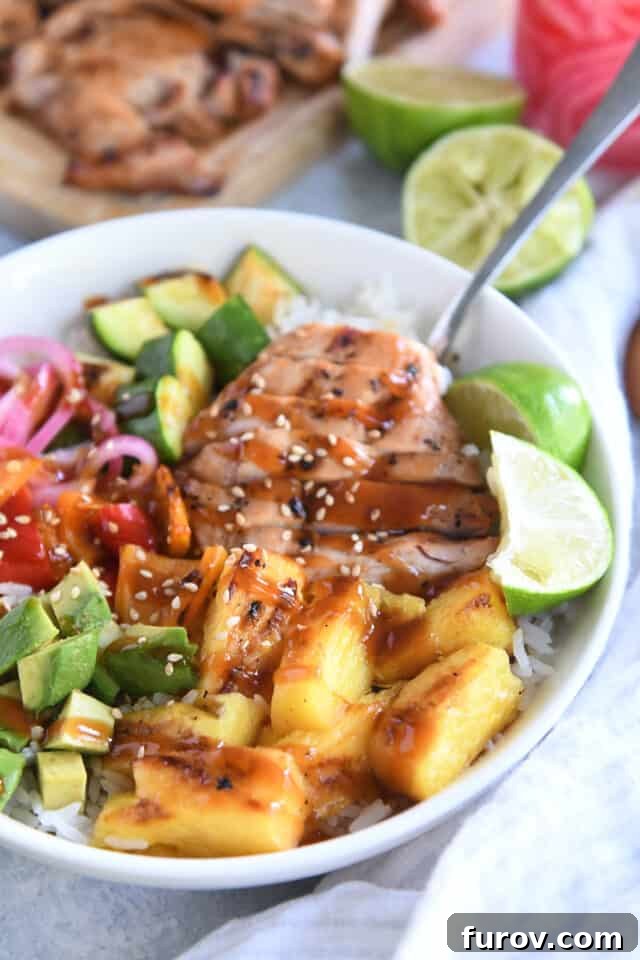 White bowl with slices of grilled chicken, fresh limes, pineapple, avocados, peppers and zucchini.