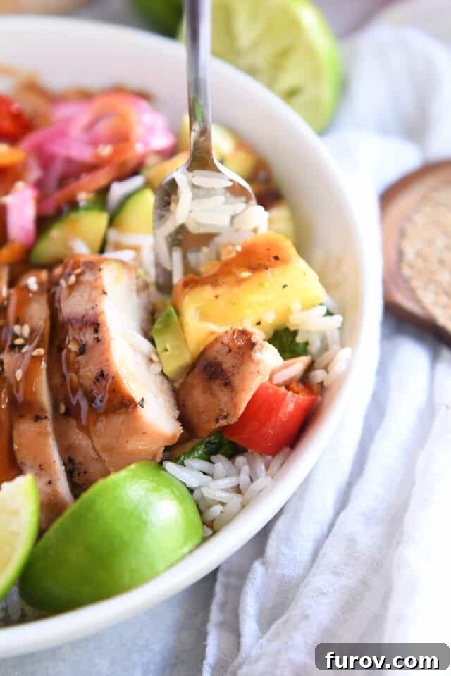 Fork scooping bite of grilled pineapple, chicken and red pepper.