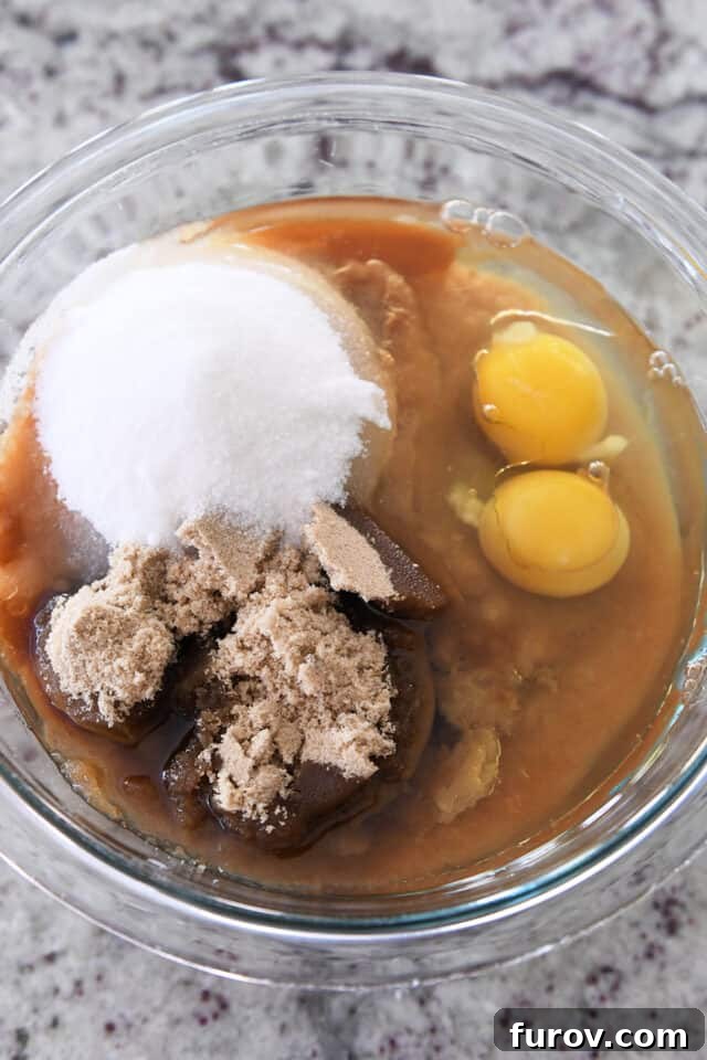 Spiced Apple Comfort Cake with Brown Butter Cream Cheese Swirl 3 Glass bowl with eggs, white sugar, brown sugar, applesauce, and oil