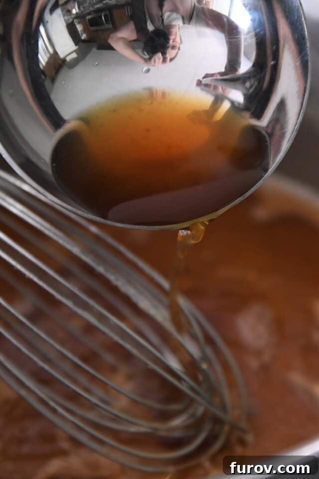 Adding hot broth to pan of gravy.