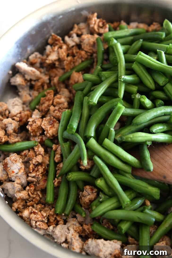 20-Minute Thai Turkey & Green Bean Dinner 4 A top-down view of the sizzling ground turkey and vibrant green beans expertly cooked in a skillet, ready to be tossed in the flavorful Thai sauce.