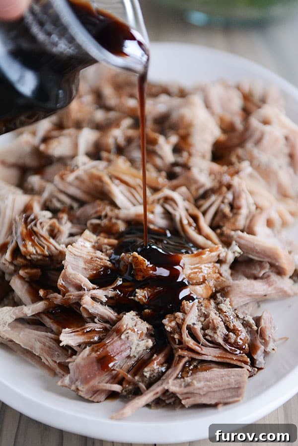 A full plate of succulent, shredded pork with a glossy balsamic glaze poured generously over the top, ready to be served as a delightful meal.