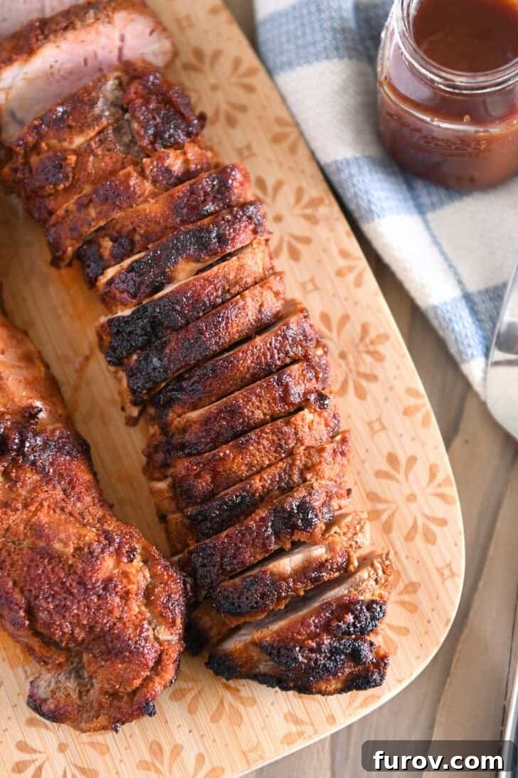 Speedy and Succulent Air Fryer Pork Tenderloin 7 Top-down view of perfectly sliced air fryer pork tenderloin on a wooden cutting board, showcasing its tender, juicy interior.