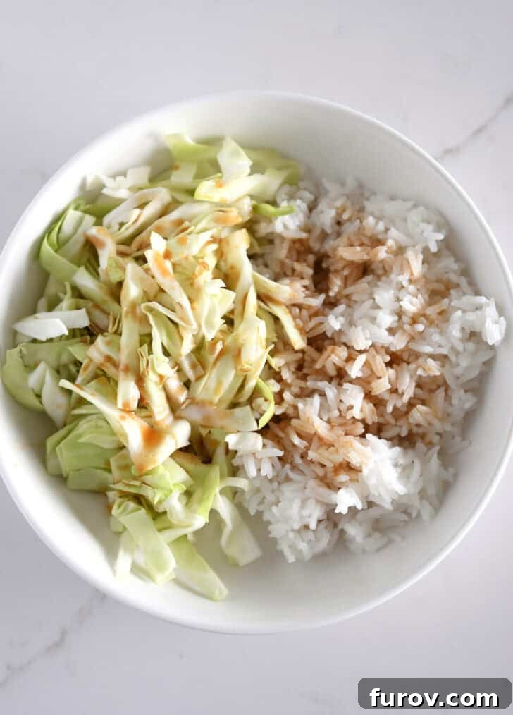 White bowl with chopped cabbage, white rice and Asian-style dressing.