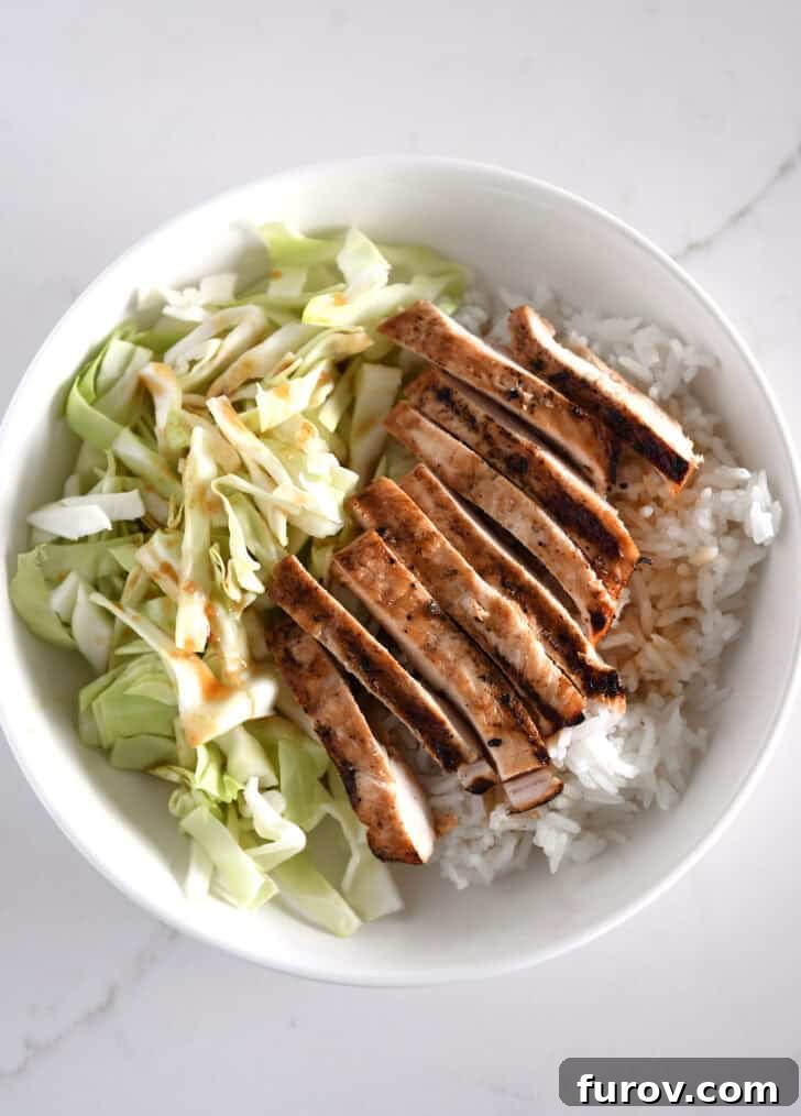 White bowl with chopped cabbage, white rice and grilled chicken.