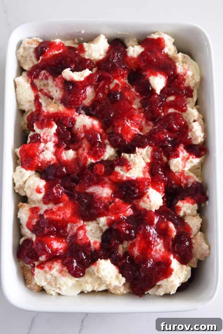 A close-up view of the beautiful layers of the Cranberry Orange Angel Food Cake Dessert, ready to be chilled.