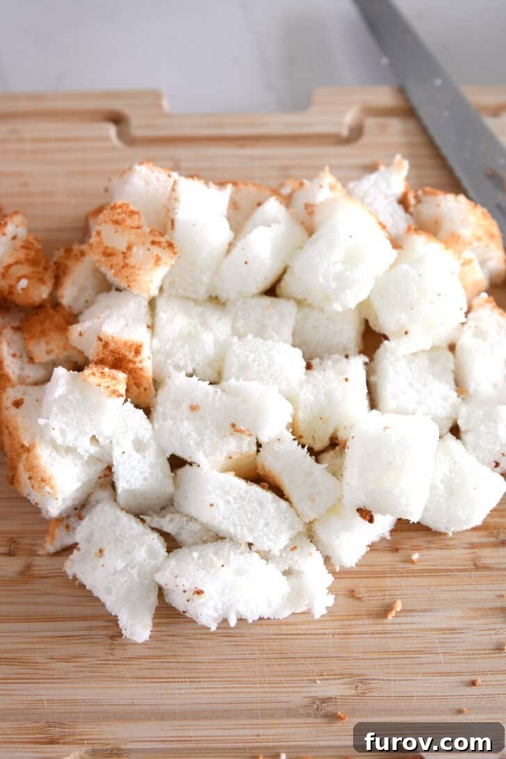 Cutting board with perfectly cubed angel food cake, ready for the cream mixture.