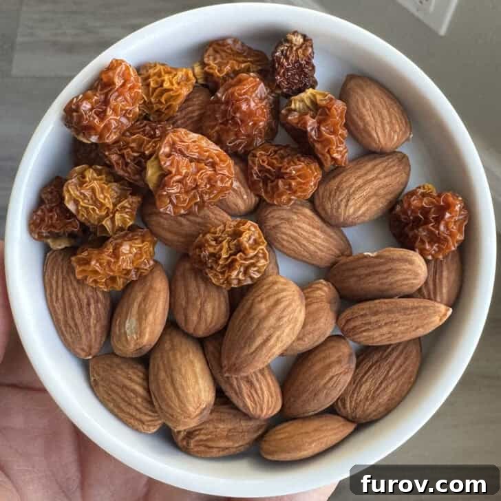 White bowl with almonds and golden berries.