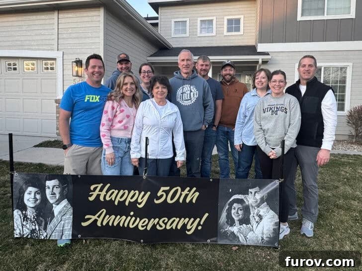 Parents and adult siblings in front of sign that reads Happy 50th Anniversary!