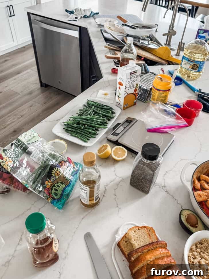 Messy kitchen counter with sink full of dishes.