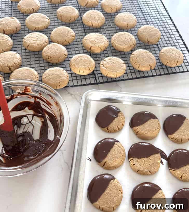 Peanut butter cookies on cooling rack with melted chocolate.