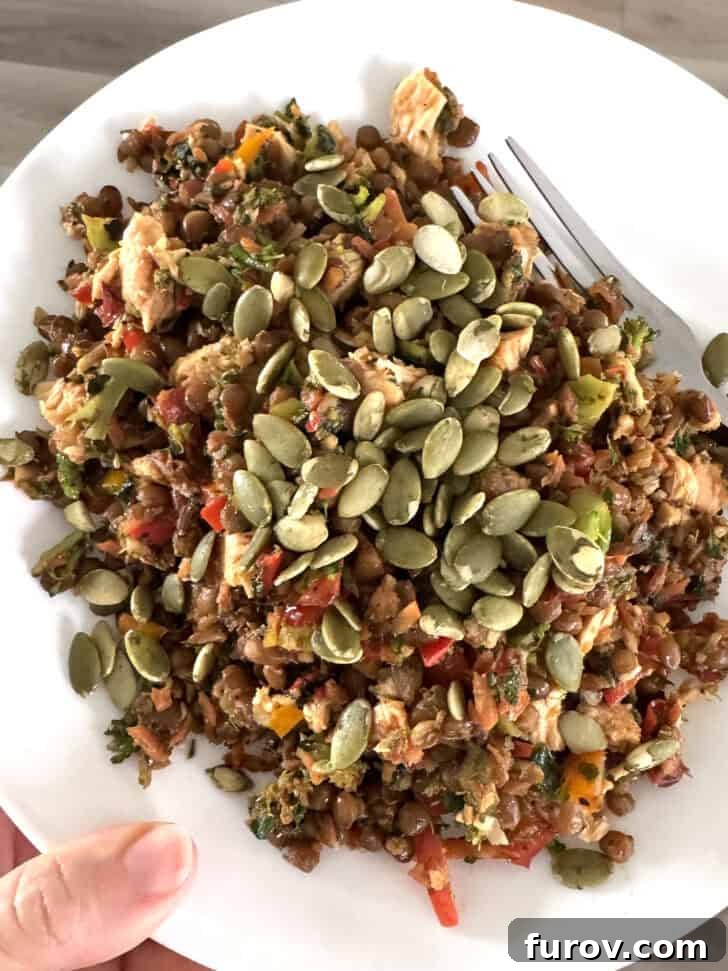 Plate of sauteed broccoli, peppers, tuna and pumpkin seeds.