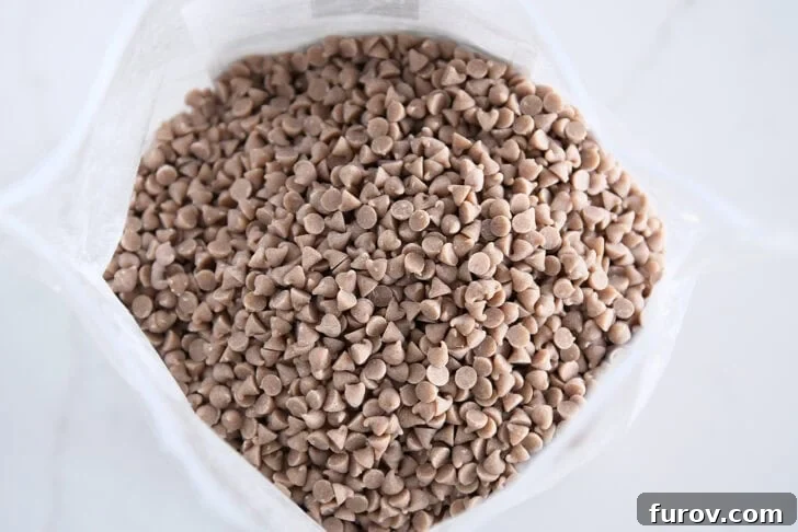 A clear bag filled with small, irregularly shaped mini cinnamon chips, illustrating the key ingredient for the bread's distinctive bursts of flavor.