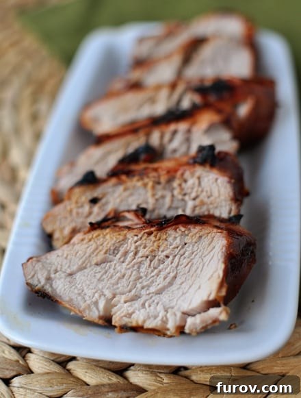 Flame-Kissed Pork Tenderloin 3 Top view of sliced grilled tenderloin on a white platter.