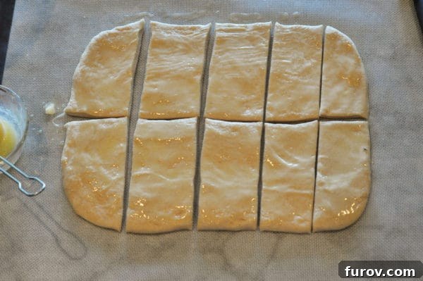 Signature Lion House Dinner Rolls 8 A large rectangle of bread dough is now cut into 10 smaller, uniform rectangles, ready for individual shaping.