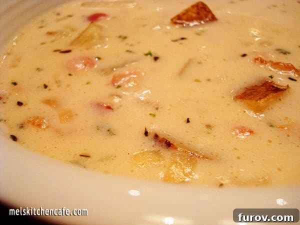 Speedy Seafood Bliss 3 Close-up of a white bowl overflowing with quick and delicious clam chowder, showcasing the rich, creamy texture and generous pieces of clam and potato.