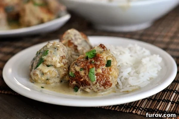 Vibrant Thai Green Curry Meatballs 4 A serving of three savory sauce-covered meatballs paired with perfectly cooked white rice on a clean white plate, ready to be enjoyed.