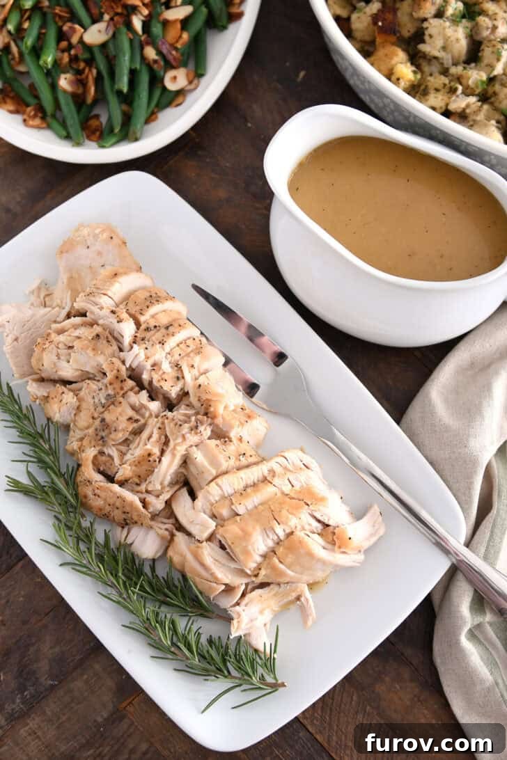 White platter with cooked turkey, rosemary, gravy boat, stuffing and green beans.