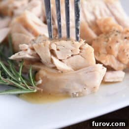 Fork piercing tender piece of slow cooker turkey.
