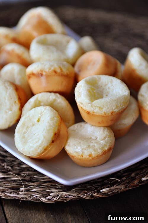 Simple Cheesy Brazilian Pao de Queijo 2 A white rectangular platter with a mountain of mini Brazilian pao de queijo breads.