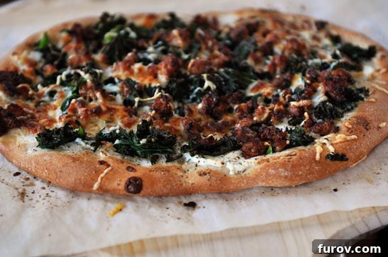 A cooked spinach and bacon topped pizza on a piece of parchment paper, showcasing a delicious combination.