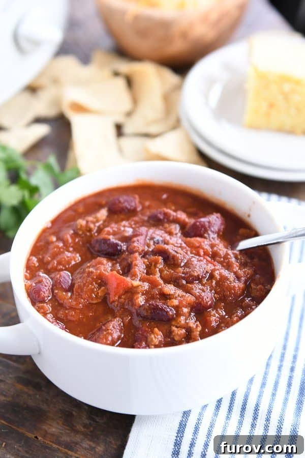 Slow-Simmered Comfort Chili 6 Classic slow cooker chili in white bowl with spoon.