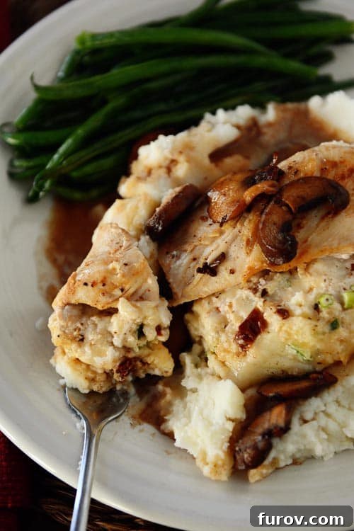 Homemade Stuffed Chicken Marsala 2 Stuffed chicken breast on a bed of creamy mashed potatoes, accompanied by vibrant green beans, all drizzled with a rich mushroom marsala sauce.