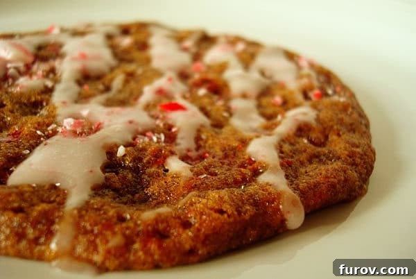 peppermint glazed molasses cookie with crushed peppermint candies on top on a cooling rack