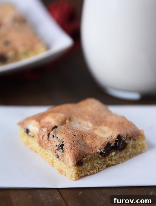 Divine Chocolate Mallow Bars 2 A chocolate chip cookie bar with a golden-brown meringue topping, sliced and ready to serve.