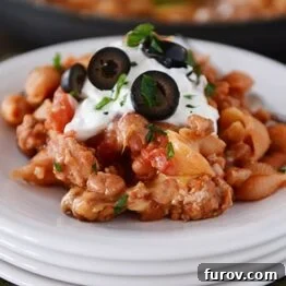 Close-up of Skillet Taco Pasta Shells, garnished with fresh cilantro and a dollop of sour cream.