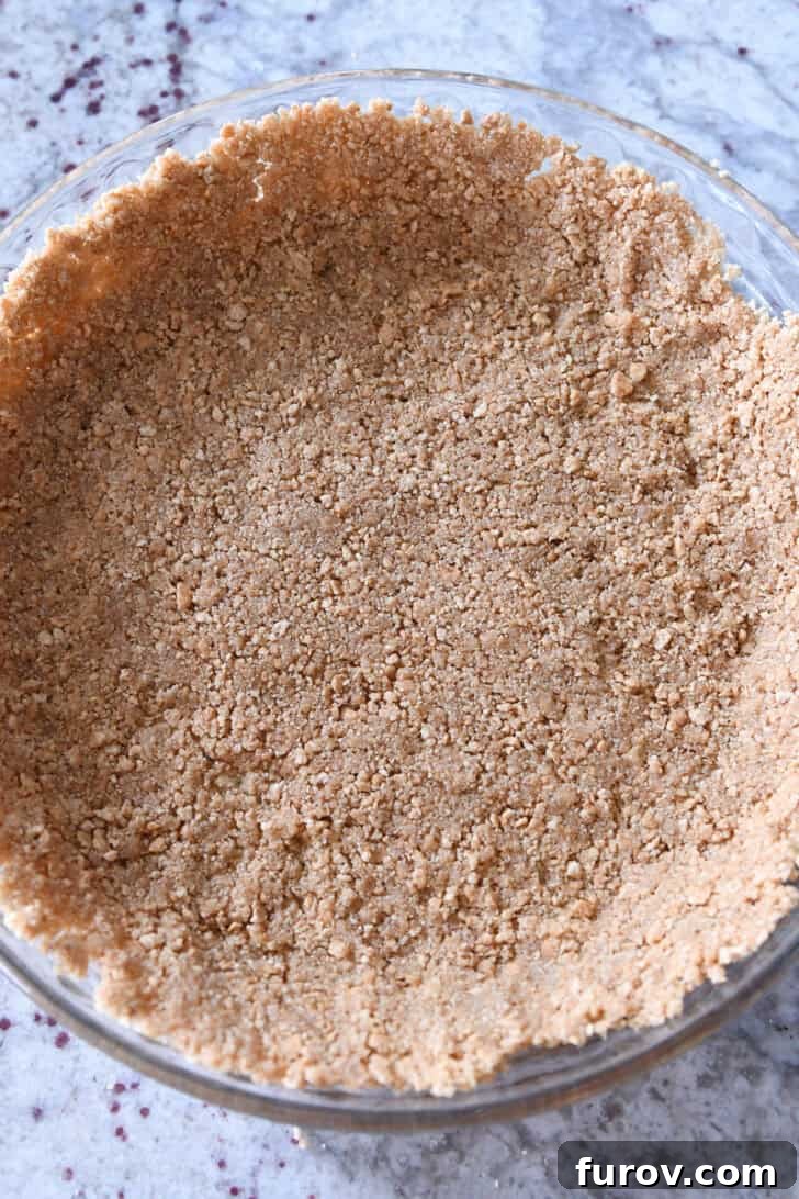Ultimate No-Bake Cheesecake 5 Top down view of a graham cracker crust in a glass pie plate.