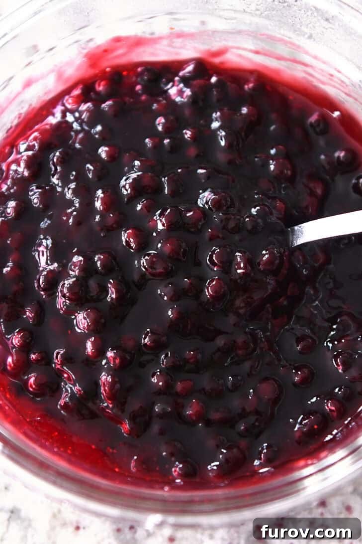 Ultimate No-Bake Cheesecake 7 Top down view of a blueberry fruit sauce in a glass bowl.